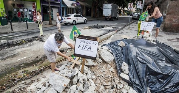 Em meio a rua devastada, moradora alfineta “exigências da Fifa”. Foto: Divulgação
