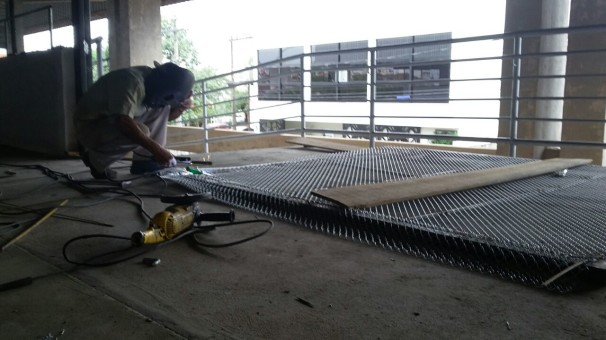 Funcionário trabalha na confecção de portões e grades para as laterais do Ginásio