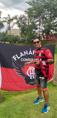 Agente prisional Andrade ao lado da bandeira do consulado do Fla em Araguari